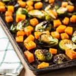 Roasted brussels sprouts and butternut squash on a sheet pan.