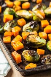 Roasted brussels sprouts and butternut squash on a sheet pan.