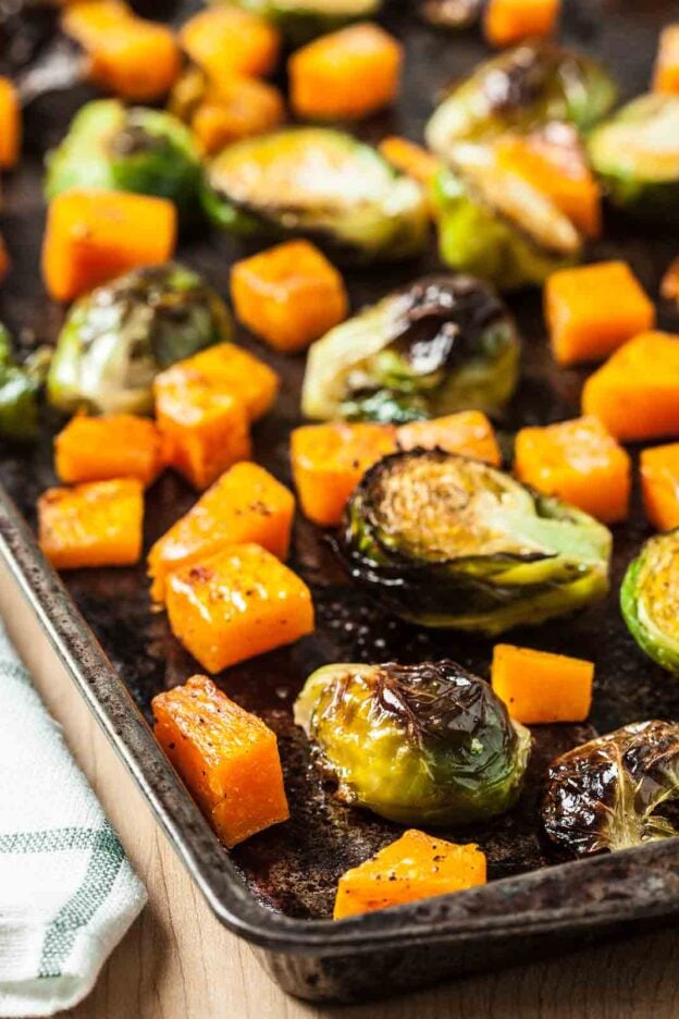 Roasted brussels sprouts and butternut squash on a sheet pan.